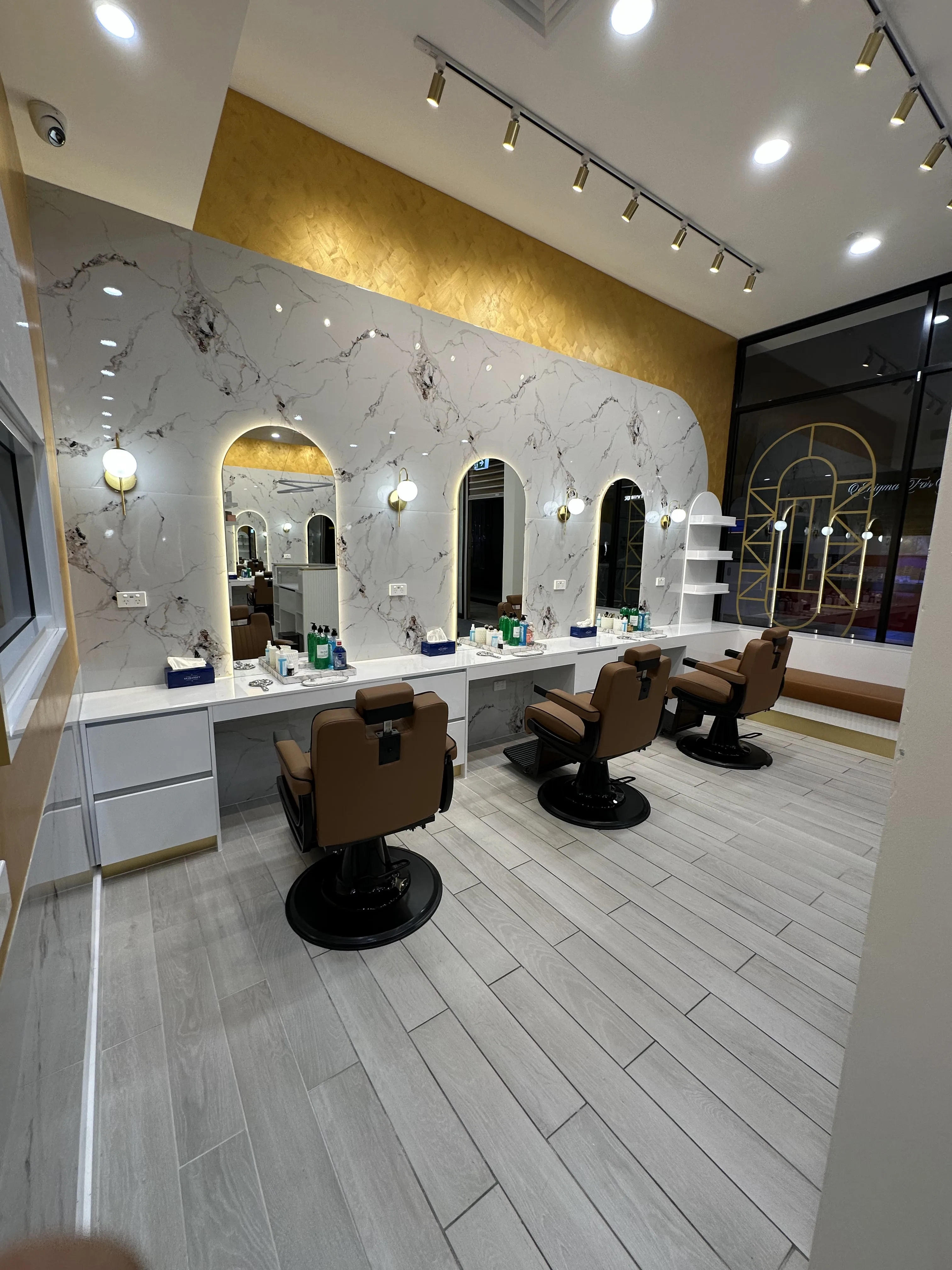 Stations receding towards the glass shopfront with the gold arch window decal — iBrow Beauty inside CS Square