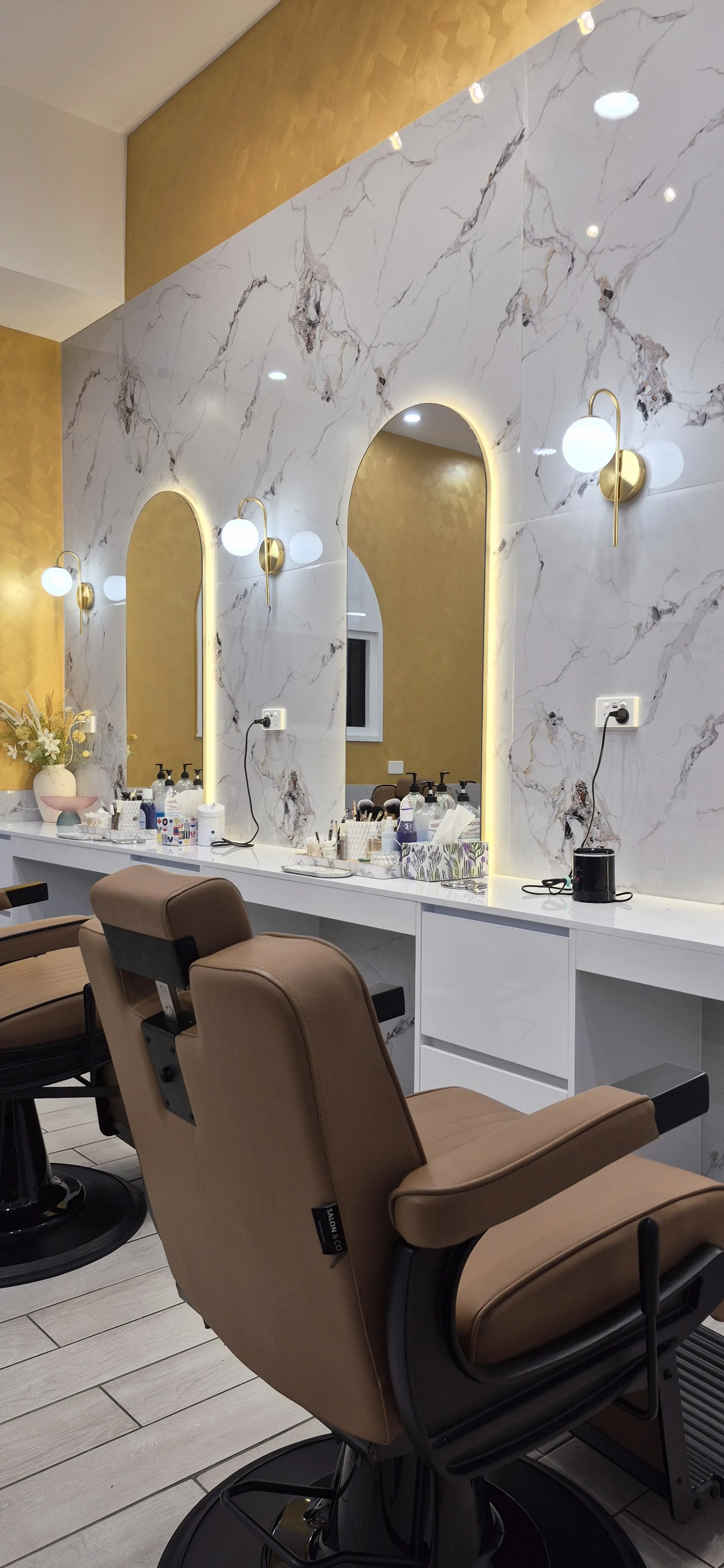 The arched mirror niche stations — marble walls and gold sconces at iBrow Beauty Caroline Springs